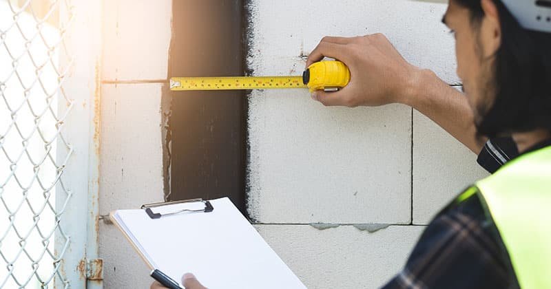 Construction-pro-taking-measurements-with-tape-measure